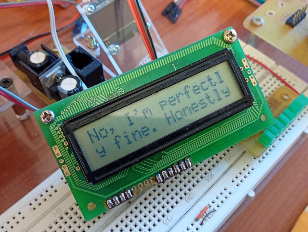 A picture of a bog standard 16 x 2 LCD module sitting on a prototyping breadboard. It is displaying the text 