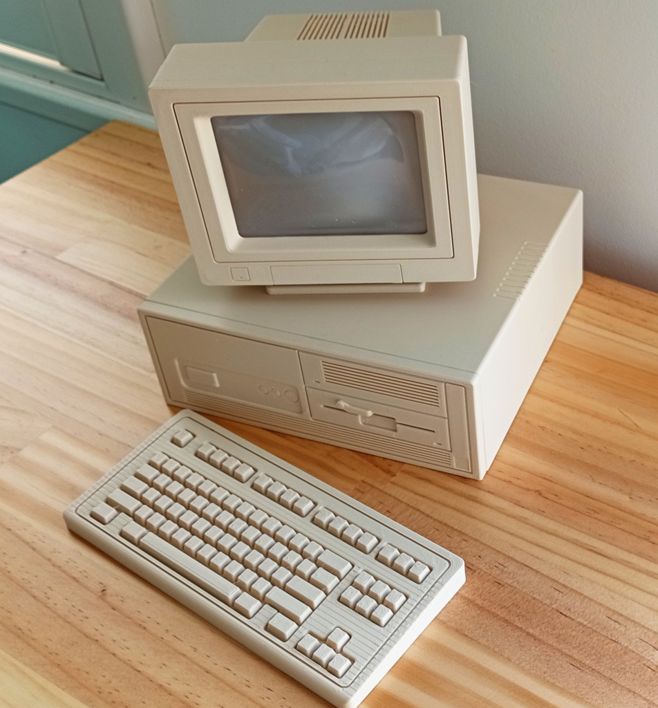 It is a beige retro desktop computer with CRT monitor sitting on top of the case that has a 5.25" HDD enclosure and a 5.25" floppy drive. There is an IBM style keyboard in front of the case. Oh no it's actually not that. It's a 3d printed model of those things at about 1/3 scale.